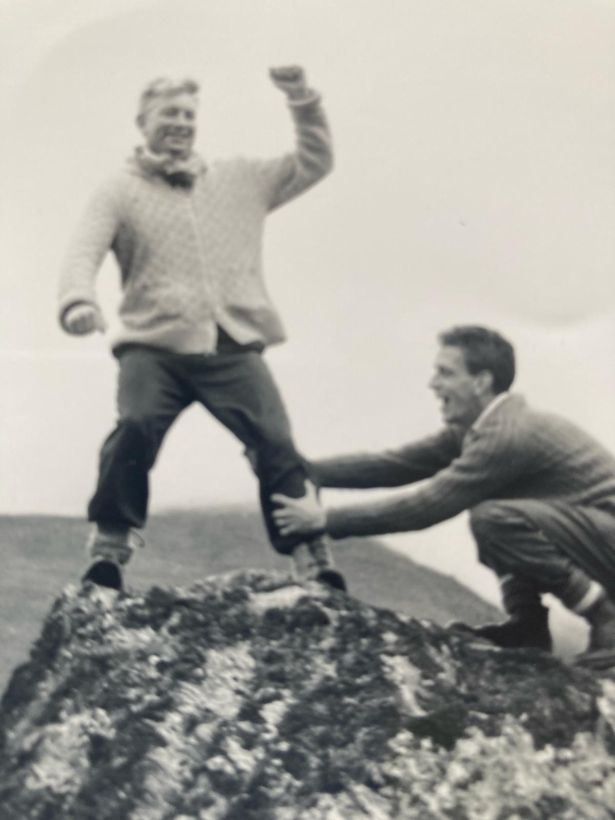 Chris and Peter hiking. Is peter holding him up, or pulling him down